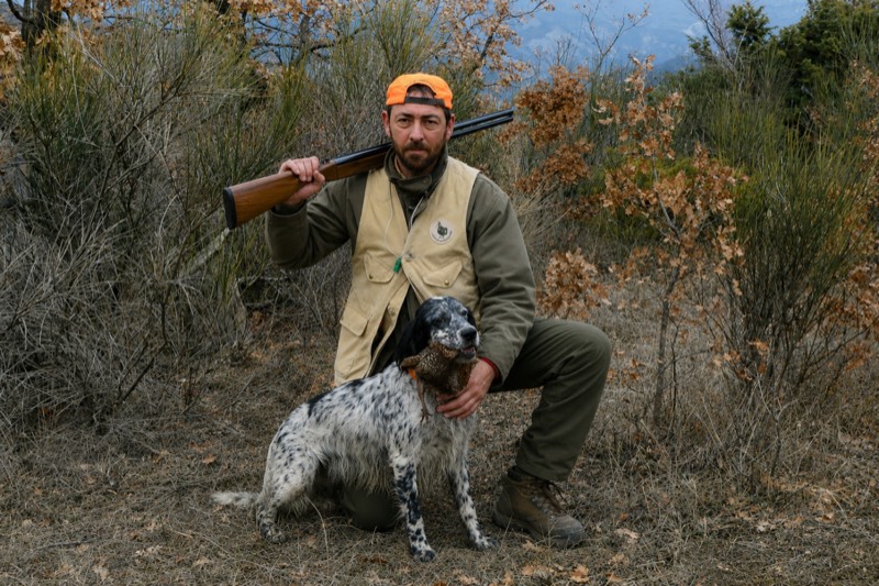 Cacciatore inginocchiato con setter e preda
